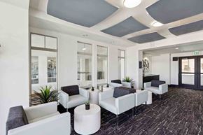 Centennial apartment for rent - a lobby with white couches and chairs and a black carpet