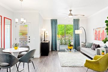 Tempe apartment for rent - A living room with a white couch, a yellow chair, and a dining table with chairs.