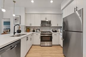 San Diego apartment for rent - an open kitchen with stainless steel appliances and white cabinets