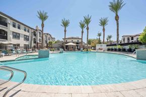 Glendale apartment for rent - Resort-style pool with blue skies, palm trees and the Zone Luxe apartments in Glendale, AZ in the backdrop.