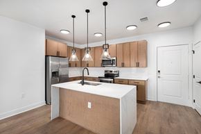Centennial apartment for rent - A kitchen with wooden cabinets and a white countertop.