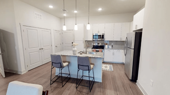 Designer white cabinetry, granite countertops, and tile backsplash