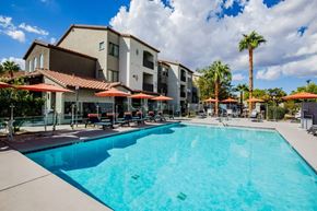 Henderson apartment for rent - A large swimming pool in front of a building with a red roof.
