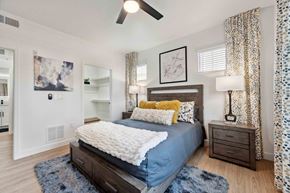 Chandler apartment for rent - A bedroom with a bed, nightstand, and a ceiling fan.