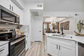 Chandler apartment for rent - A kitchen with white cabinets and a black stove top oven.