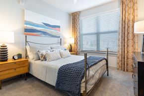 Aurora apartment for rent - A bedroom with a large bed and a painting on the wall.