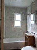 Orlando apartment for rent - A white toilet is in a bathroom with a tub, sink and mirror.