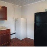 Orlando apartment for rent - A black refrigerator sits next to a white wall.