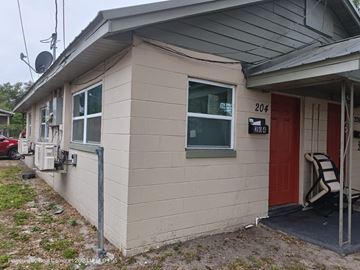 Orlando apartment for rent - A small house with a red door and a satellite dish on the roof.