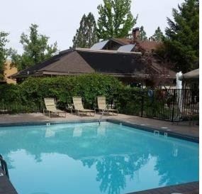 Reno apartment for rent - A pool in a backyard with a house and trees in the background.