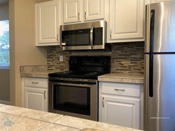 Reno apartment for rent - A kitchen with white cabinets and a black stove top oven.