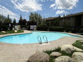 Reno apartment for rent - A swimming pool surrounded by rocks and bushes.