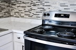 Davis apartment for rent - A modern stove top with a digital display is in a kitchen with a marble counter.