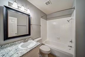Redding apartment for rent - A bathroom with a white toilet, sink, and bathtub.