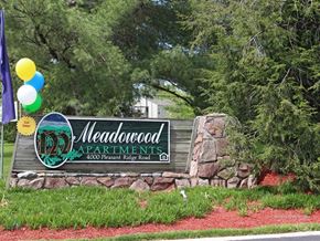 Knoxville apartment for rent - A sign for Meadowood Apartments is displayed in front of a green area.