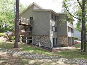 Knoxville apartment for rent - A two-story house with a balcony and a stone wall.