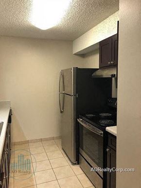 Knoxville apartment for rent - A small kitchen with a black refrigerator and stove.