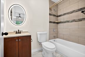 Los Angeles apartment for rent - A bathroom with a white toilet and a round mirror.