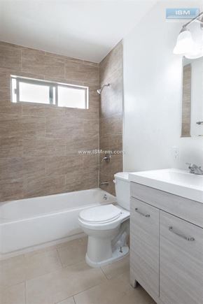 Los Angeles apartment for rent - A white toilet in a bathroom with a brown tiled wall.
