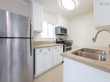 Los Angeles apartment for rent - A kitchen with a stainless steel refrigerator and a granite countertop.