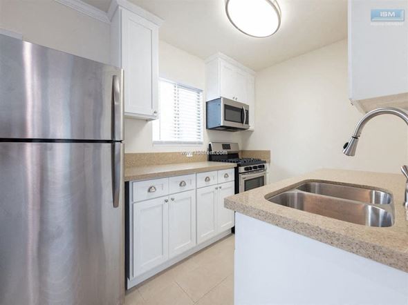 Los Angeles apartment for rent - A kitchen with a stainless steel refrigerator and a granite countertop.