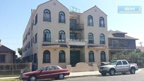 Los Angeles apartment for rent - A red car is parked in front of a two-story building.