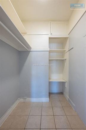 Los Angeles apartment for rent - A long hallway with a white wall and tile floor.