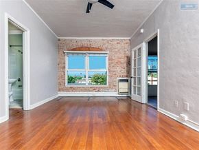 Los Angeles apartment for rent - A room with a brick wall and wooden flooring.