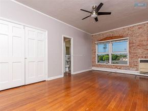 Los Angeles apartment for rent - A room with a ceiling fan and wooden floors.