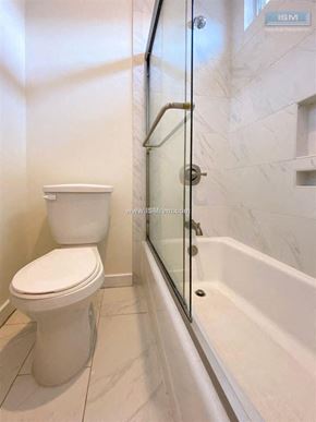 Los Angeles apartment for rent - A white toilet sits next to a glass shower door in a bathroom.