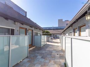 Los Angeles apartment for rent - A sunny day at the courtyard of a building with glass walls and tiled floors.