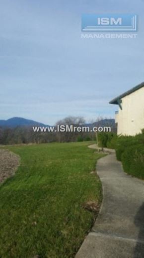 Redding apartment for rent - A grassy pathway leads to a building with the text