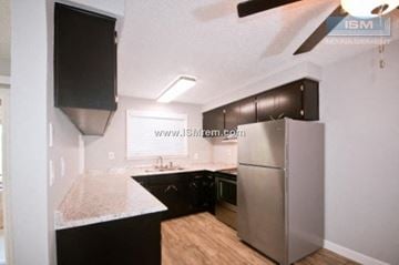 Redding apartment for rent - A kitchen with a black counter top and a stainless steel refrigerator.