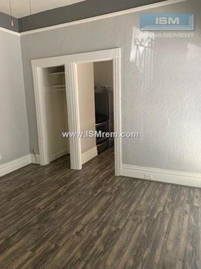 San Francisco apartment for rent - A room with a wooden floor and a doorway leading to another room.