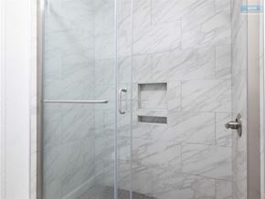 Sherman Oaks apartment for rent - A white tiled shower with a glass door and a silver handle.