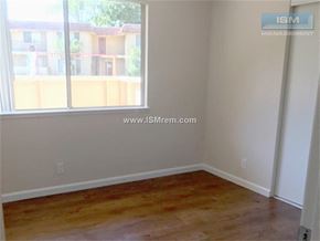 Stockton apartment for rent - A room with wooden flooring and a window overlooking a building.