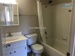 Stockton apartment for rent - A white bathroom with a toilet, sink, and bathtub.