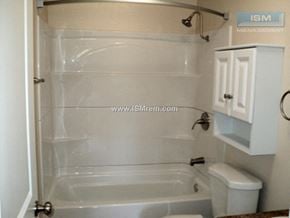 Turlock apartment for rent - A white bathroom with a tub, toilet, and cabinet.