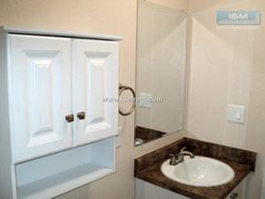 Turlock apartment for rent - A white bathroom cabinet with a sink and mirror.