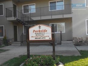 Turlock apartment for rent - A sign for Parkside Apartments is in front of a building.