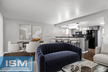 Chico apartment for rent - A modern living room with a blue velvet sofa and a dining area in the background.