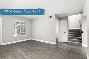 Chico apartment for rent - A spacious room with wooden flooring and a staircase leading to another room.