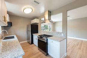 Los Angeles apartment for rent - A kitchen with a granite countertop and a black refrigerator.