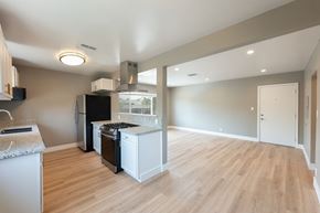 Los Angeles apartment for rent - A kitchen with a black fridge and white cabinets.