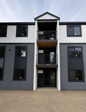 Champaign apartment for rent - A modern two-story building with a balcony on the second floor.