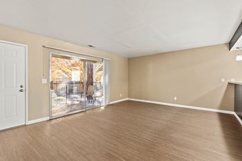 Spacious living room with balcony access and wood style flooring