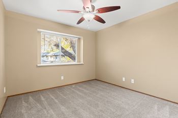 Vacant bedroom with carpet and ceiling fan