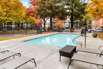 Pool with autumn trees and lounge chairs