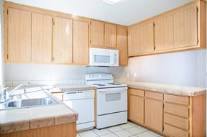 Chico apartment for rent - Kitchen with oak cabinets and white appliances at Pomona Townhomes Apartments, Chico, California
