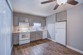 Redding apartment for rent - A kitchen with a refrigerator, oven, sink, and cabinets.